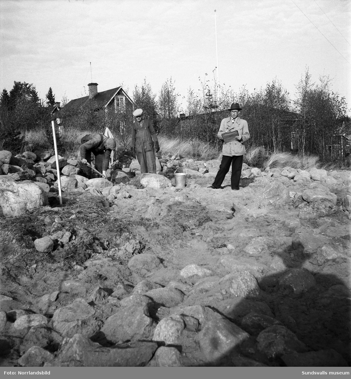 Gravfynd i Stöde. Tre män undersöker ett stenröse.