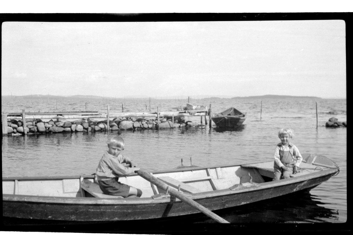 Brødrene Juliust og Rolf jr. Sundt sitter i en robåt, Stavern. Fotografert 1928-1929.