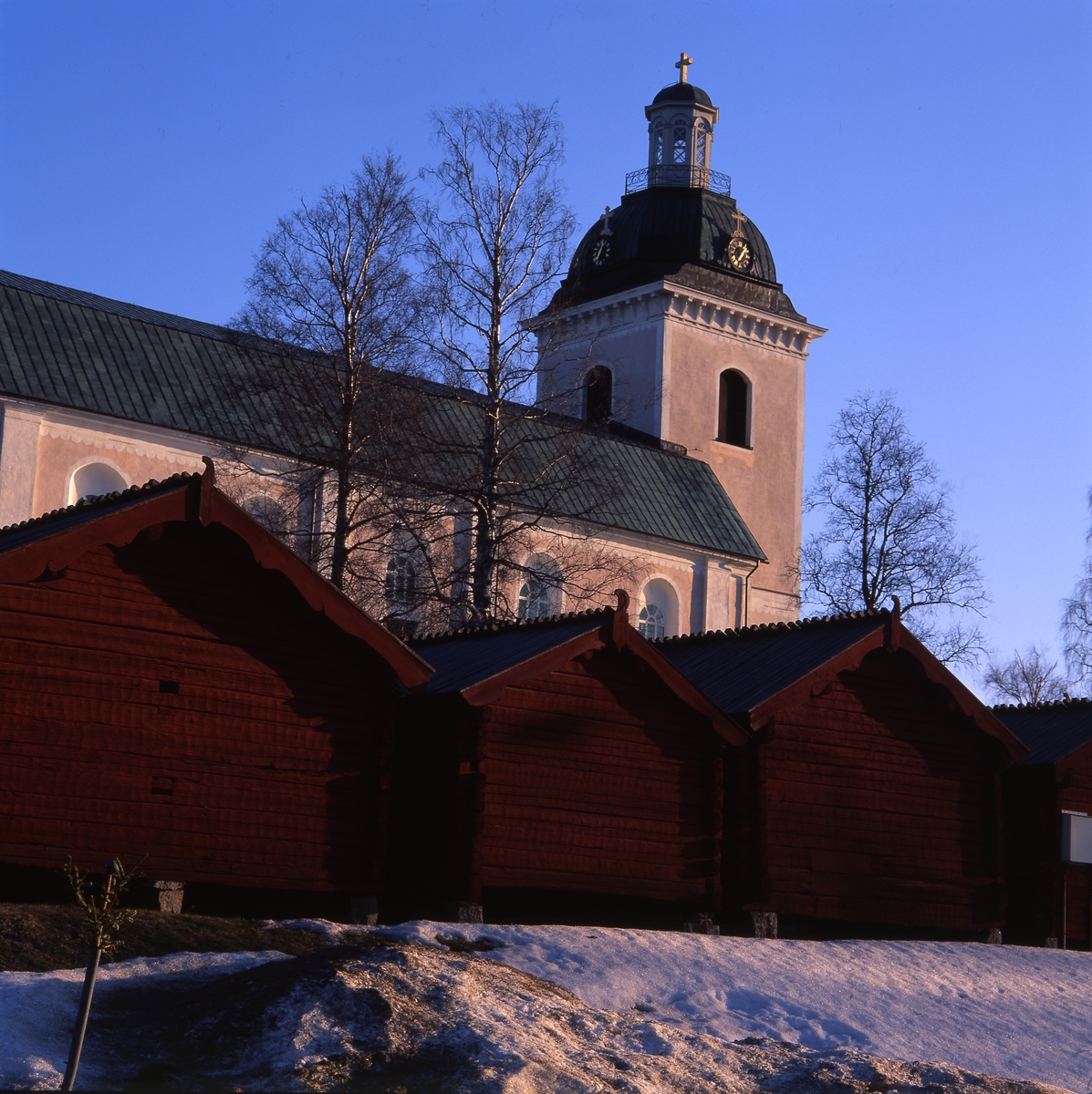 Färila kyrka och kyrkstallar i aftonsol, 22 april 2001.