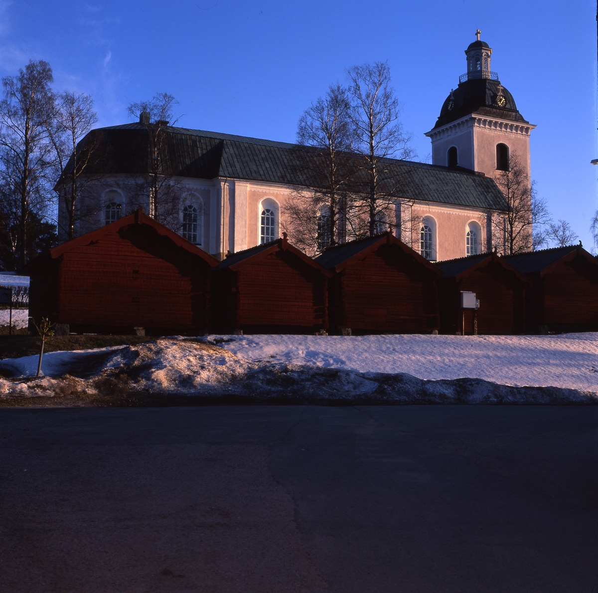 Färila kyrka och kyrkstallar i aftonsol, 22 april 2001.
