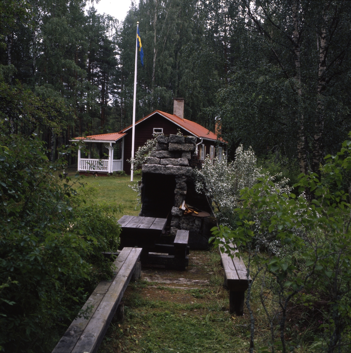 Författaren Albert Vikstens torp vid Ängratörn. Flaggan är hissad och utespisen tänd och omgiven av blommande fruktträd. Ängratörn-veckan med Daisy och Gunnar 10-15 juli 2000.