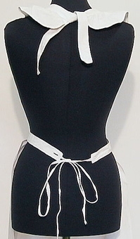 Vitt förkläde med bröstlapp, hängslen och knytband. Förklädet har sydda stråveck på bröstlappen.