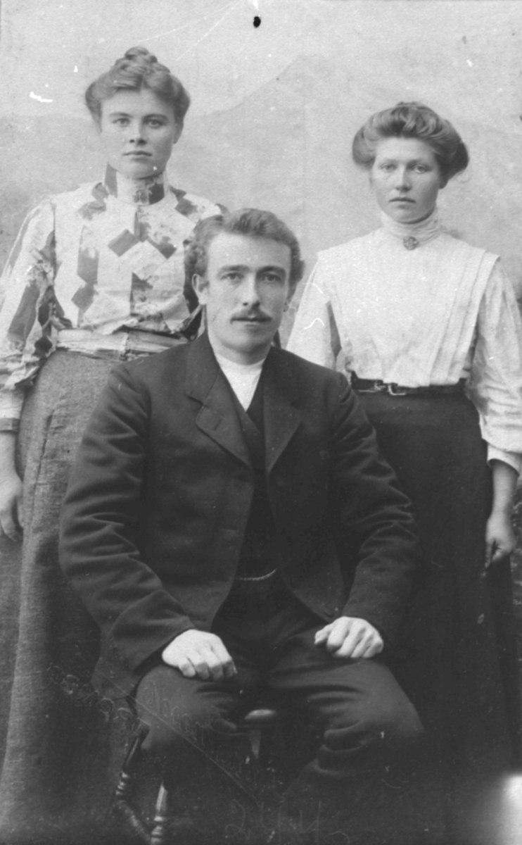 Atelierportrett av to damer og en mann. Tidspunkt ca 1900. Foran Johan Rasmussen, hans søster Rebekka til venstre Til høyre Danielle Johnsen fra Lonkan.