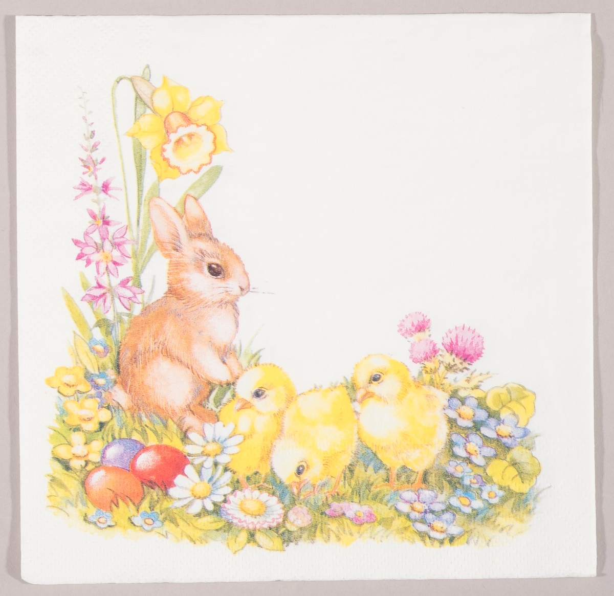 En kanin og tre kyllinger i en blomstereng med påskelilje og andre vårblomster og tre kulørte påskeegg.