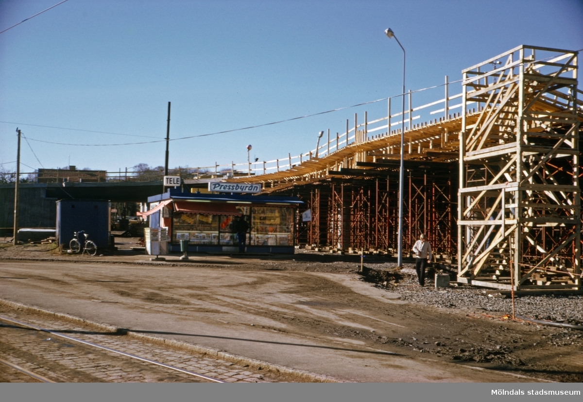 Pressbyrån vid vändslingan för 4:ans spårvagnslinje i Mölndal, ca 1974-1975. Vidare ses byggnationen av den nya Mölndals Bro.