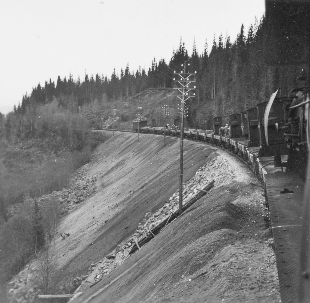 Grustog på Nordlandsbanen trukket av damplokomotiv type 63a nr. 2343. Grusen er hentet fra Spølrem grustak mellom Laksfors og Eiterstraum stasjoner på Nordlandsbanen.  Grusen losses med håndmakt.