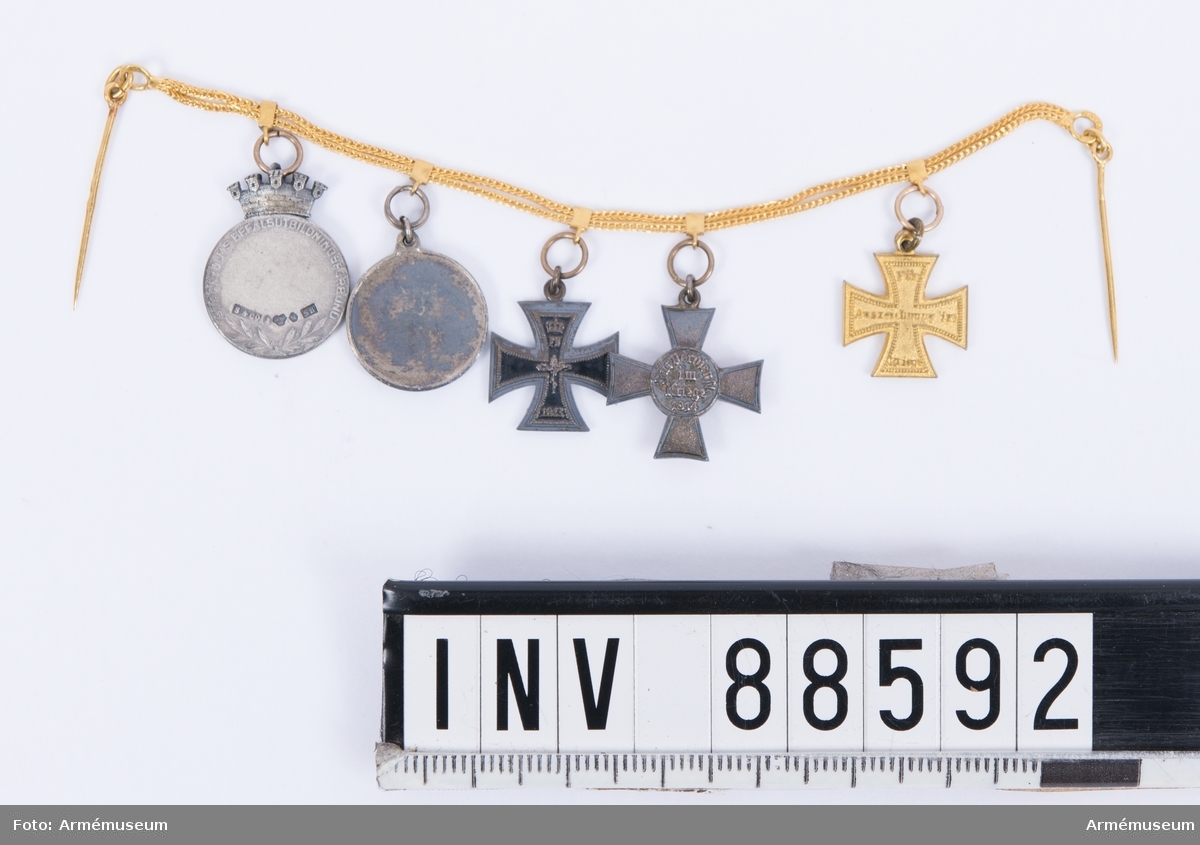 Fem miniatyrmedaljer på guldkedja med nålar, att bäras till frack.
1. Militärförtjänstkorset från Mecklenburg-Schwerin, i guld med storhertig Friedrich Franz II:s initialer och 1914, i rött, gult och ljusblått band.
2. Hansakorset från staden Hamburg, med stadens vapen i centrum på det rödemaljerade korset, i rött och vitt band.
3. Järnkorset av II klassen, 1914 i svart-vitt band.
4. Okänd medalj med fransk lilja.
5. Medalj för Stockholms befälsutbildningsförbund, med texten "fäderneslandets försvar".