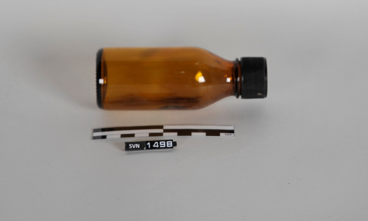 Brun sylindrisk flaske med sort kork