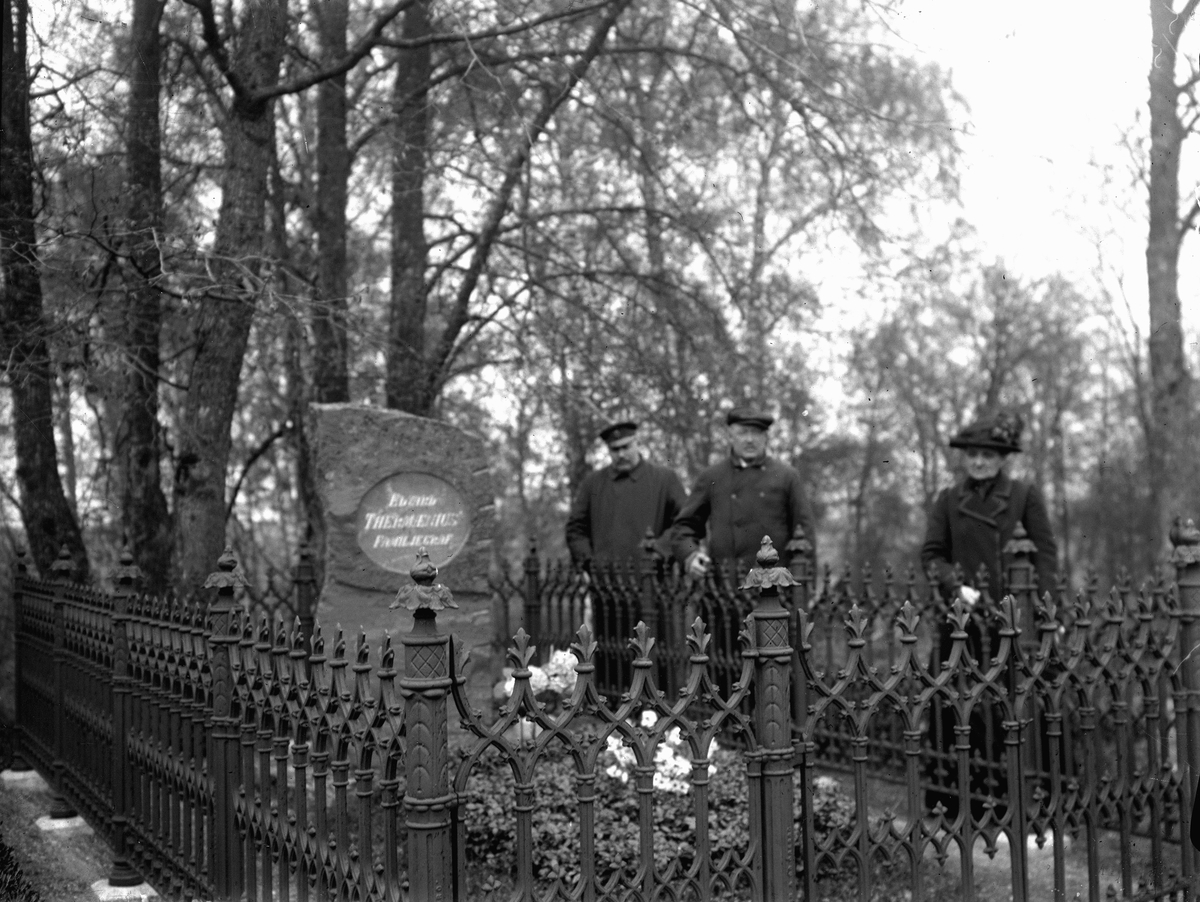 Thermaenius familjegrav på Kumla kyrkogård. Tre personer vid graven.
Texten på gravstenen är "Edvard Thermaenius Familjegrav". Edvard dog 1894.