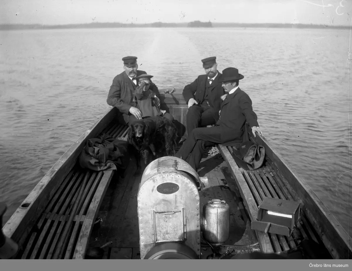 Män, barn och en hund i en båt på Tisaren. Troligen Löföbåten.
Gottfrid, Fredrik och Björn Thermaenius.
En kameraväska på sitsen till höger.