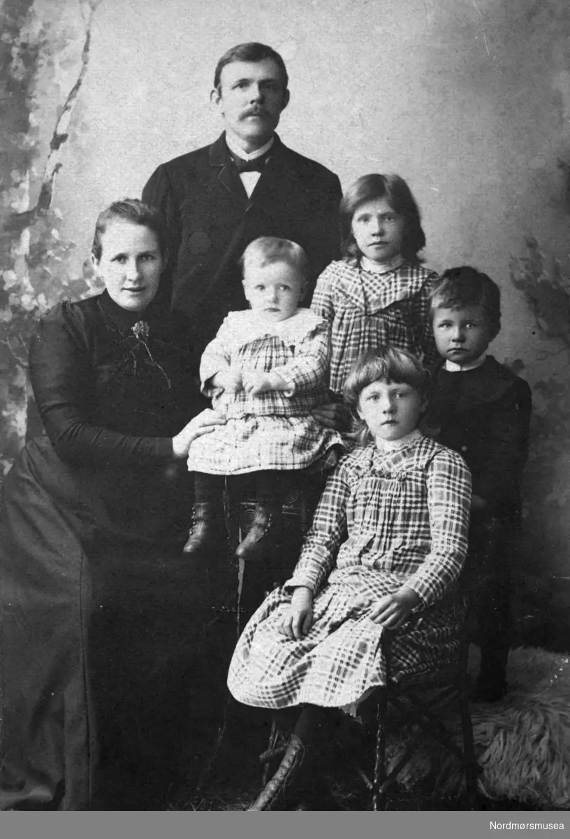 Foto av en familie på seks. Trolig bosatt i Kristiansund. En samling slektsfoto fra familien Farstad/Nordtvedt i Kristiansund. Giver av samlingen er Aase Nordtvedt. Fra Nordmøre museums fotosamlinger.
