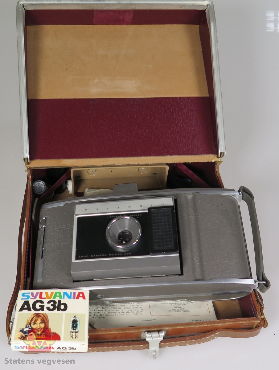 Polaroid fotoapparat med bruksanvisning og tilbehør, alt ligger i en veske.