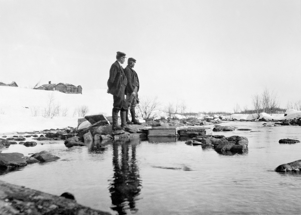 Bildet viser utklekking av fisk i Hemsedal, Buskerud. To personer ses på bildet. Utklekking, klekking av fisk, to personer. Fiskekultivering.