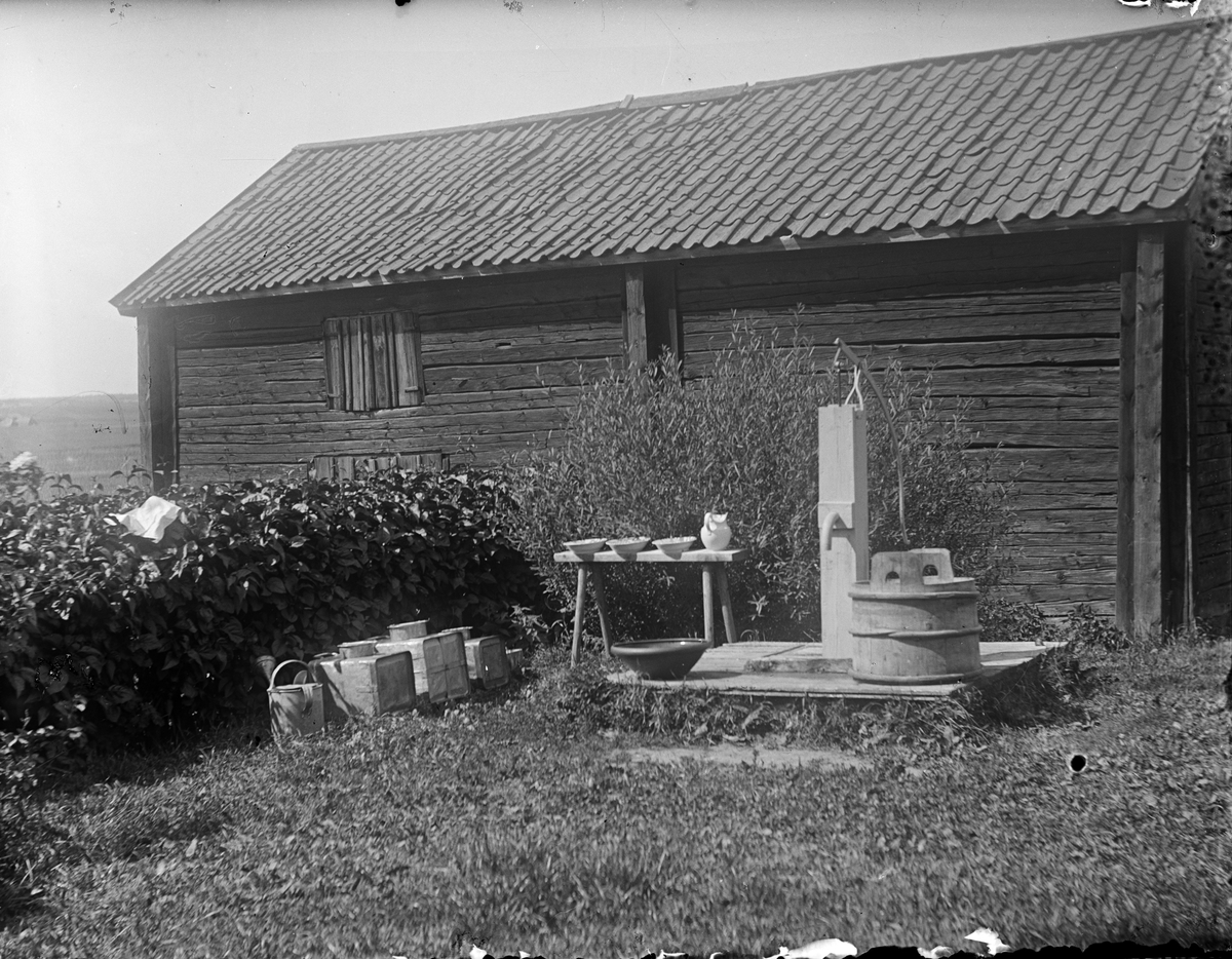 Förvaringskärl vid vattenpump, Alinders gård, Sävasta, Altuna socken, Uppland i början av 1900-talet