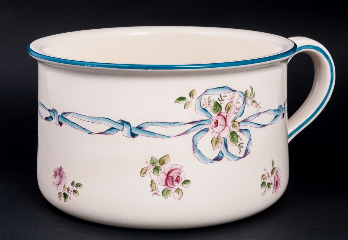 Potta av flintgods, tillhörande tvättservis i 6 delar, vit glasyr, blomdekor. Tillverkad av Rörstrand.