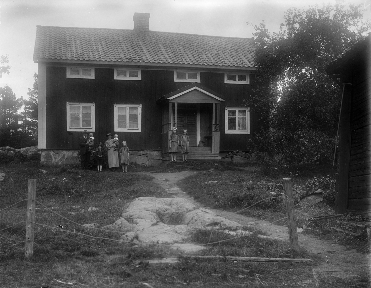 Sigfrid Andersson med familj framför bostadshus, Bärtbo, Tärna socken, Uppland 1925