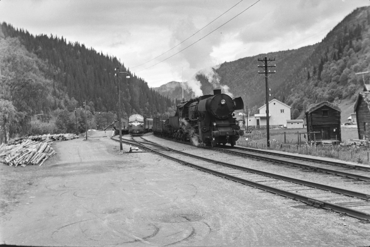 Underveisgodstoget fra Trondheim til Hamar over Røros forbikjøres av dagtoget fra Trondheim til Oslo Ø på Kotsøy stasjon. Godstoget trekkes av damplokomotiv type 63a nr. 5860, dagtoget av diesellokomotiv type Di 3.