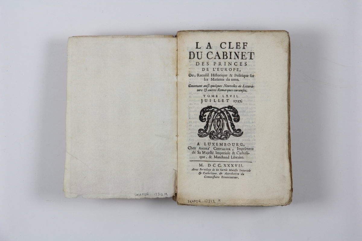 Bok, pappband "La clef du cabinet des princes de
 l´Europe", del 67, tryckt i Luxemburg 1737.
Marmorerat band med blekt rygg, påklistrade pappersetiketter med titel och volymens nummer.  Med skurna snitt.
