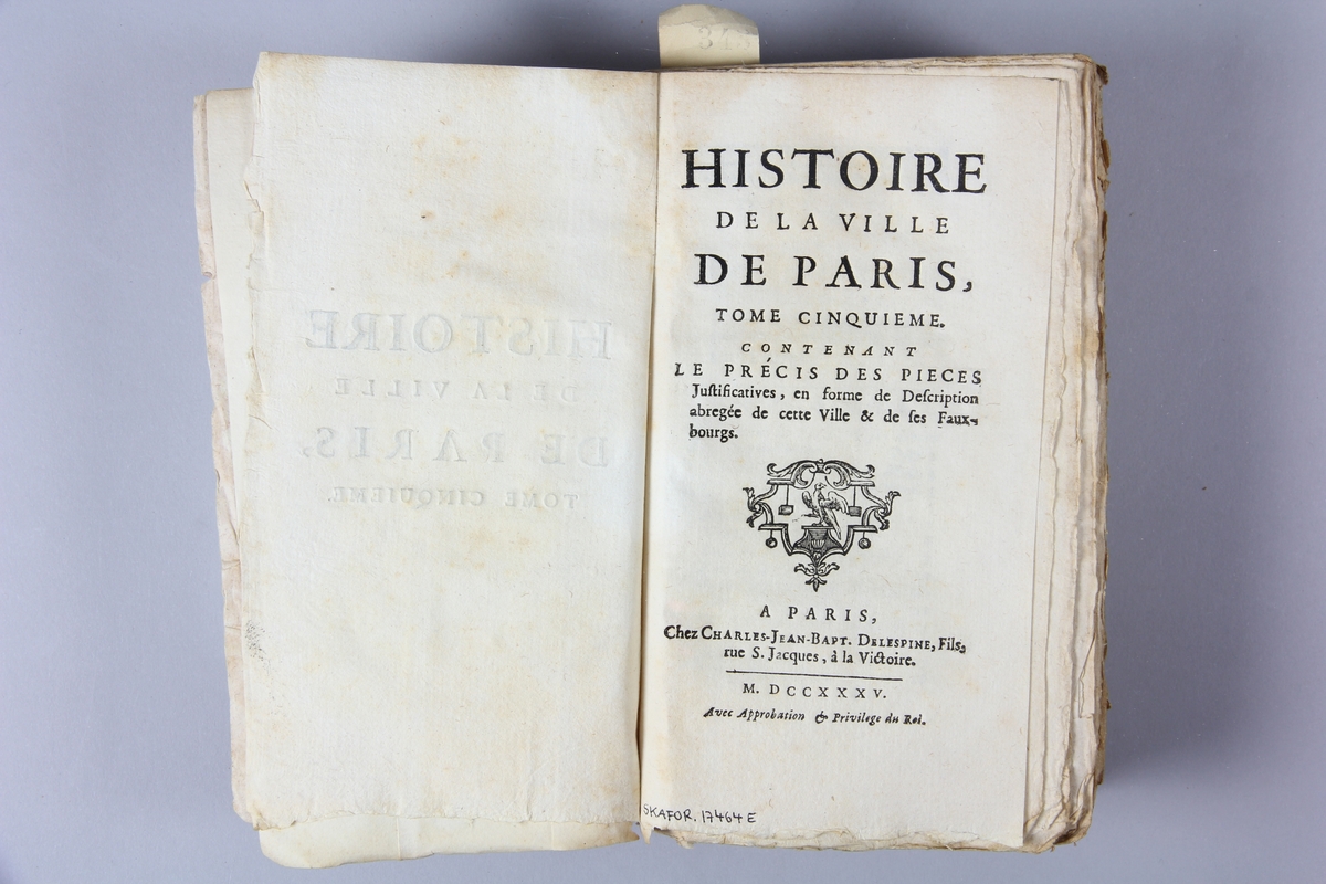 Bok, häftad, "Histoire de la ville de Paris", del 2, tryckt 1735 i Paris.
Pärm av marmorerat papper, oskuret snitt. Blekt rygg med etikett med titel och samlingsnummer. Ej uppskuren.