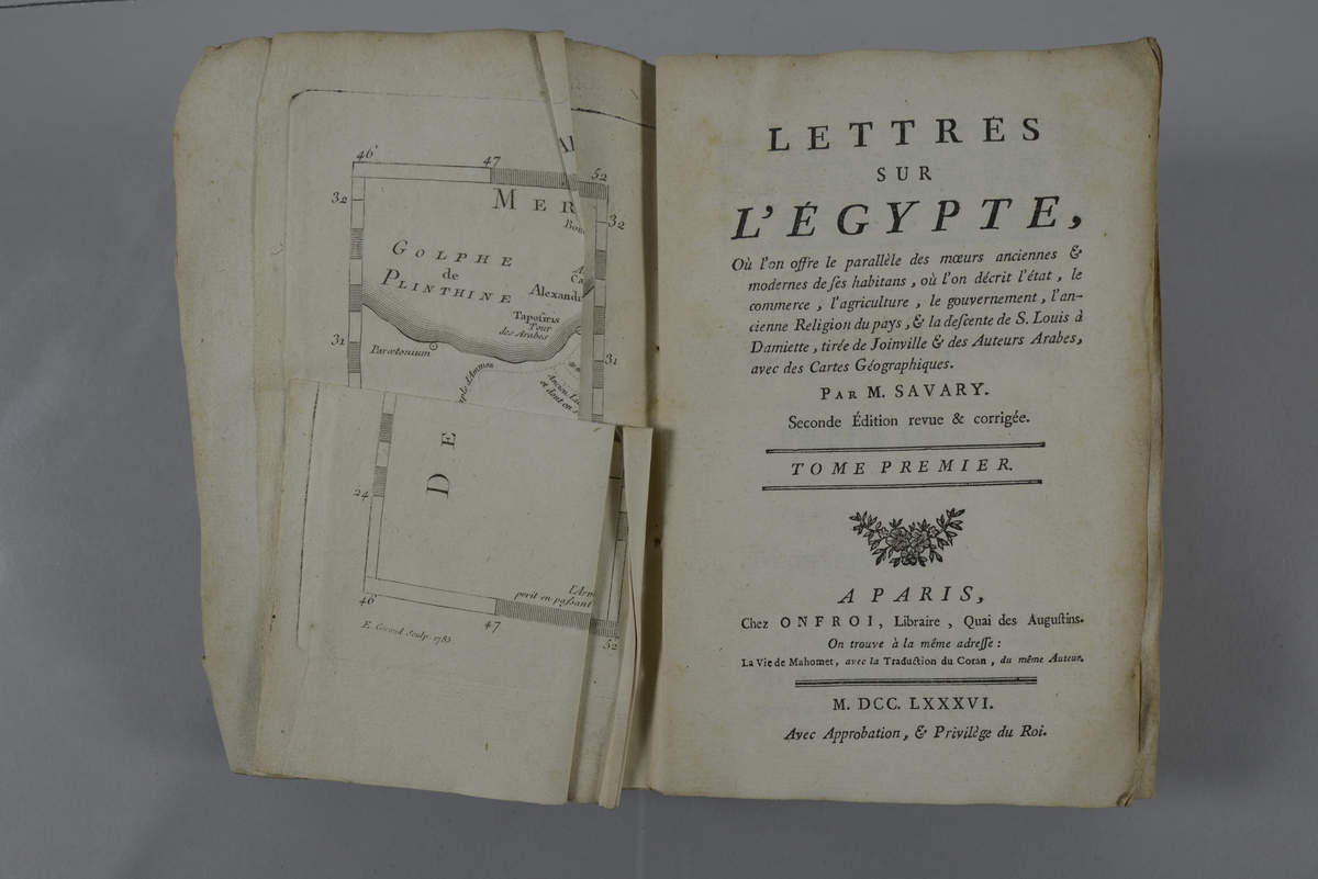 Bok, pappband: "Lettres sur l Égypte", del1, skriven av M. Savary och tryckt i Paris 1786. Pärmen klädd med marmorerat papper med text ur annan bok. Med skurna snitt.
På ryggen pappersetikett med volymens nummer och titel. Med karta.