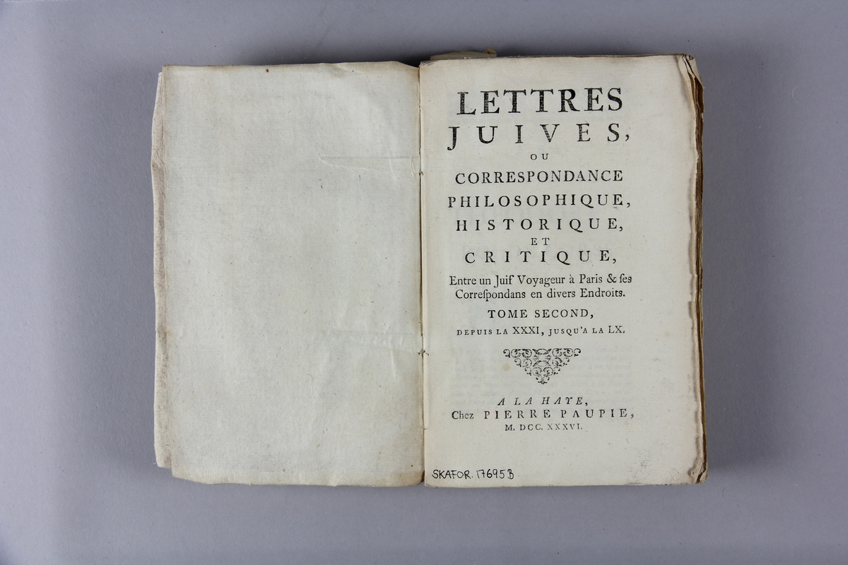 Bok, häftad, "Lettres juives",  del 2, tryckt i Haag 1736.
Pärm av marmorerat papper, oskurna snitt. På ryggen klistrade pappersetiketter med volymens namn och samlingsnummer. Ryggen blekt.
