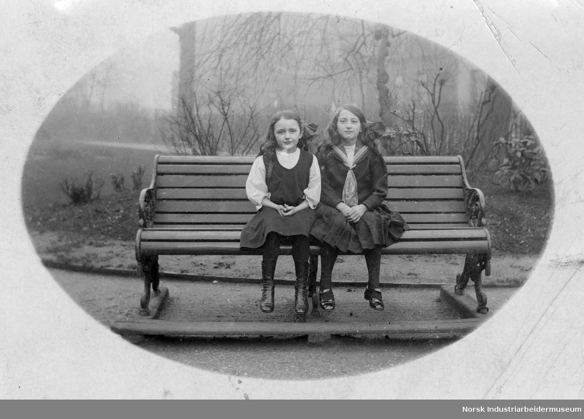 To jenter på en benk.