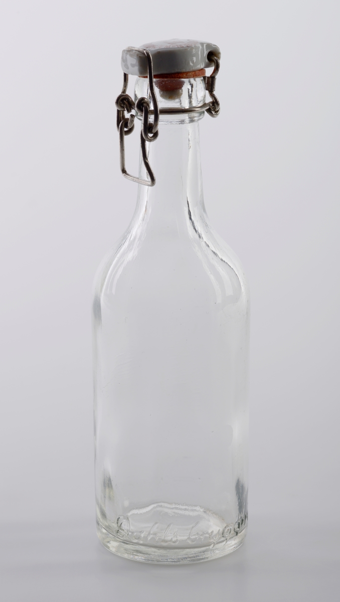 Seks identiske blanke glassflasker med patentkork. Korken er laget av hvit porselen med oransje gummiring og metallfeste. På korken er det påført tekst, se "Påført tekst/merker". Flaskene er fra E. C. Dahls bryggeri.