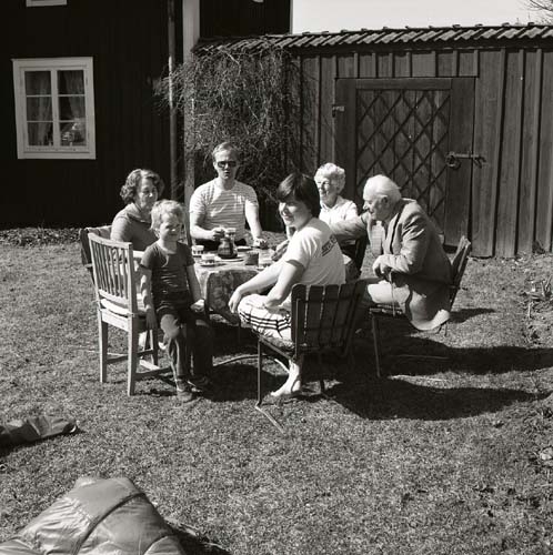 En familj fikar ute i trädgården vid gården Sunnanåker, 1984.