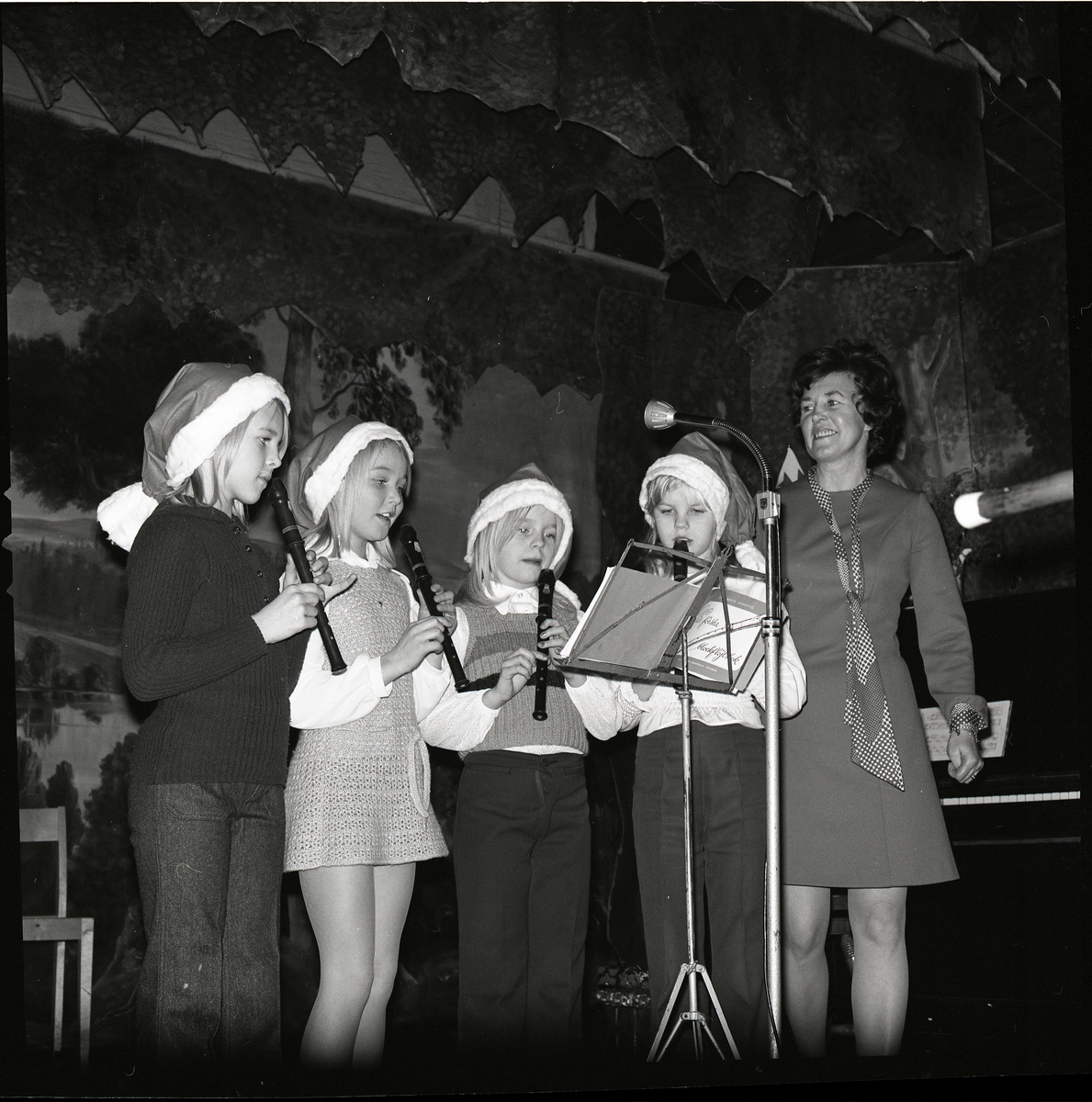 Fyra barn uppträder med att spela blockflöjt på en scen, 1972.