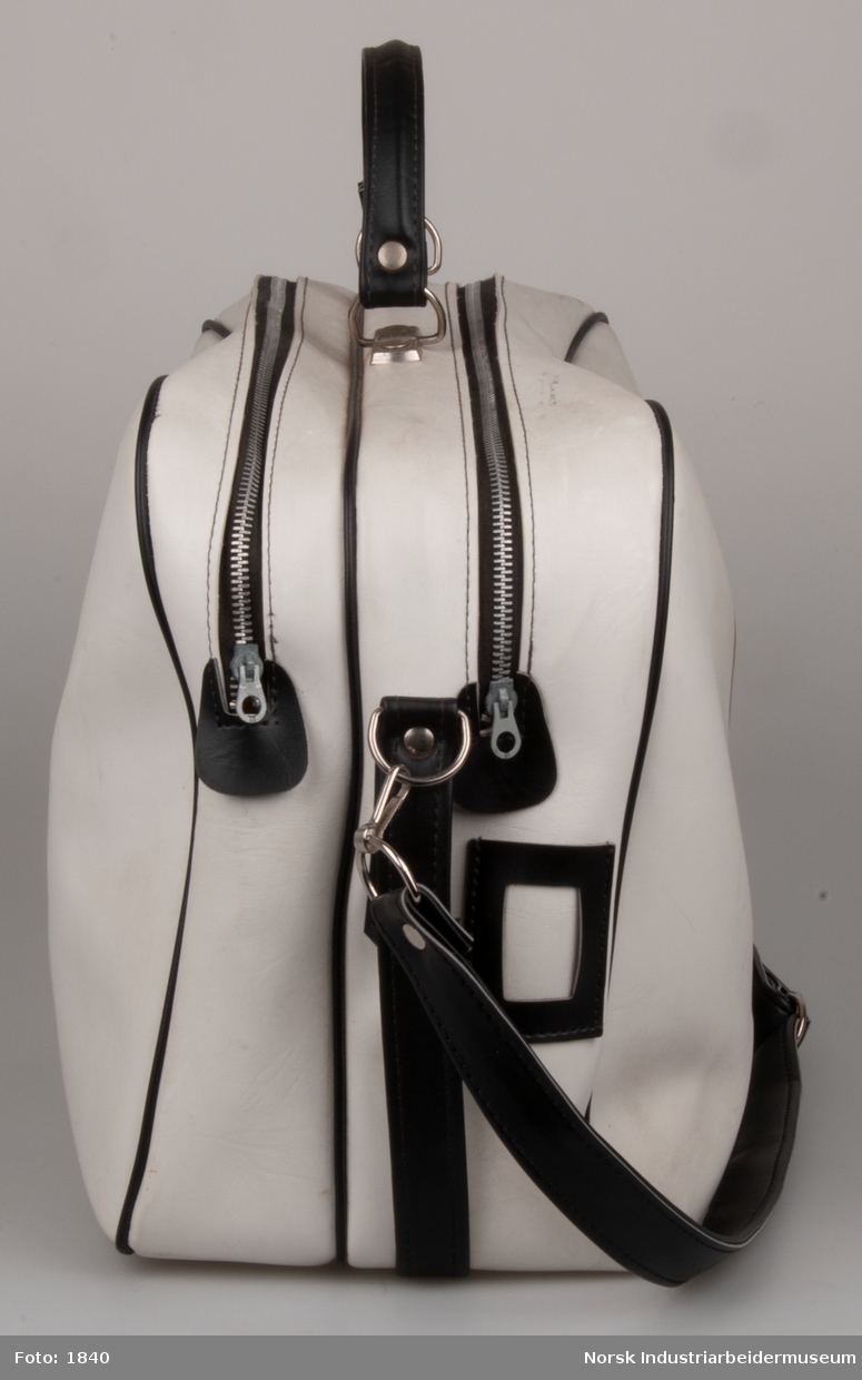 Hvid sportstaske med sort Norsk Hydro logo og sorte dekorationer. Sort skulderrem. Forsynet med to lynlåse af metal. 20x40x60 cm.
