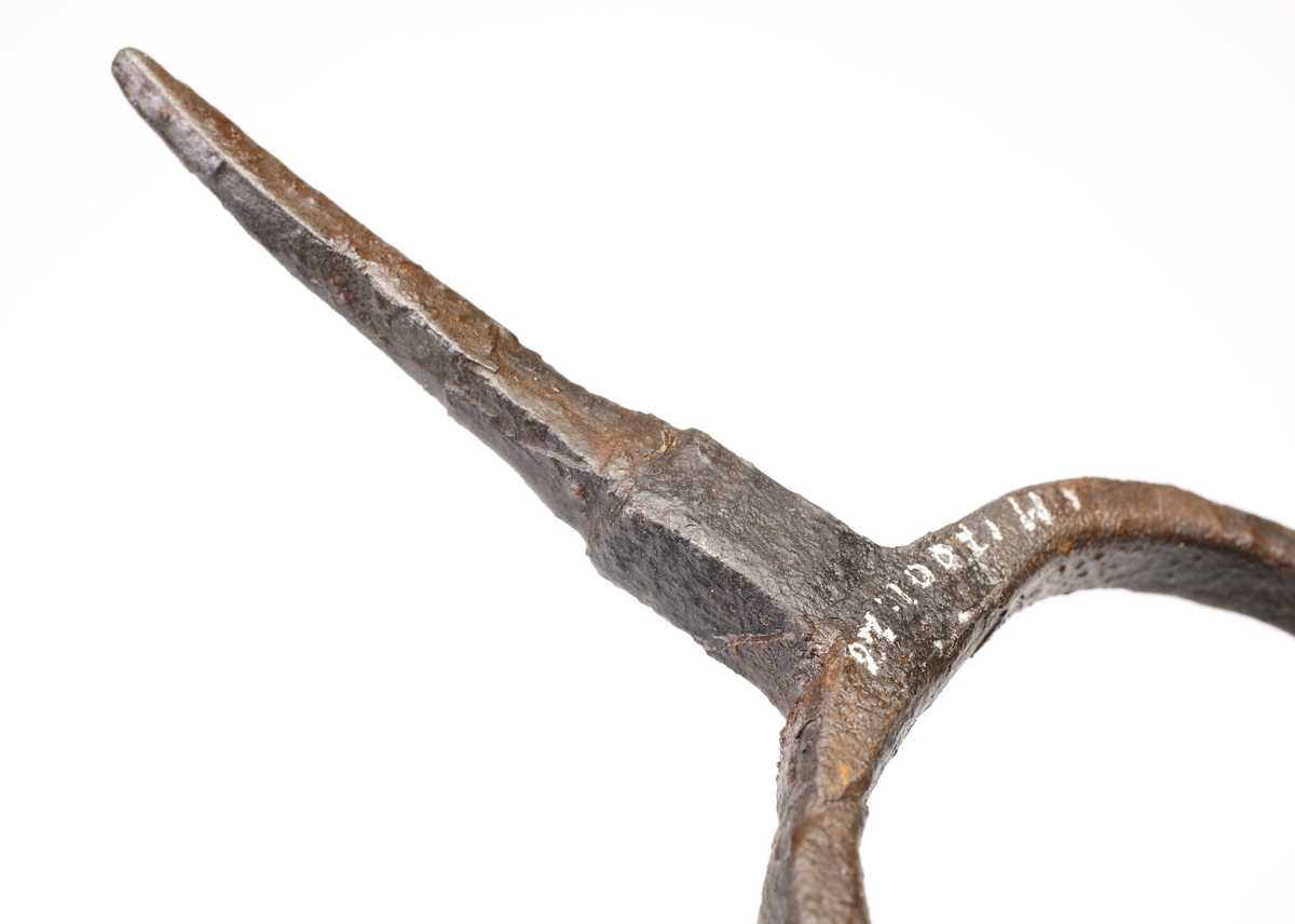 En forkett eller muskötgaffel, vilken fungerat som ett stöd för en musköt. Mjukt böjd form med inrullande ändar. Väl smidd. Spetsig tånge.