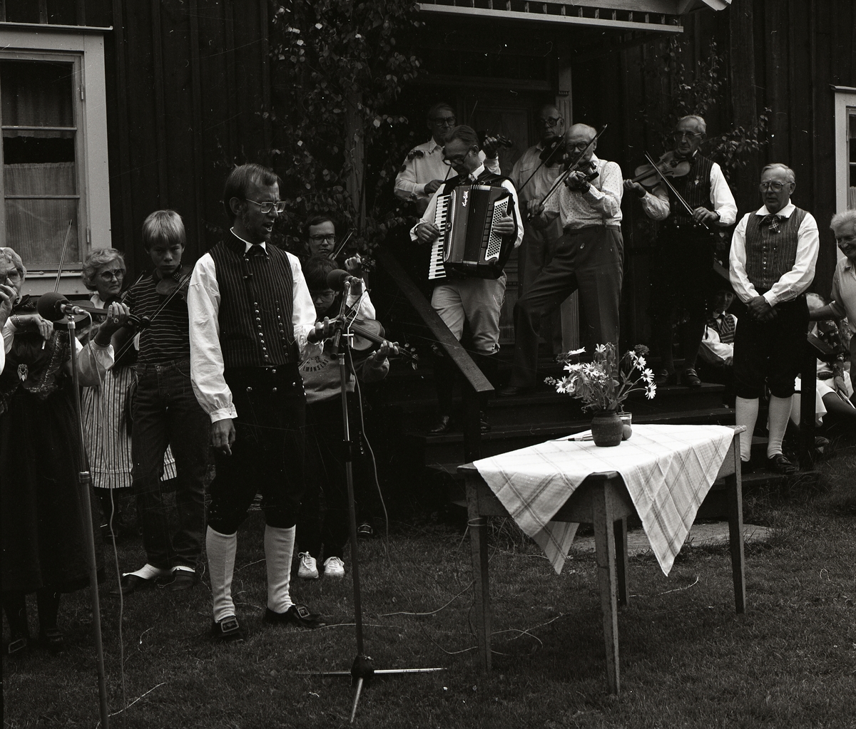 Ett spelmanslag samt en sångare upptäcker vid Rengsjöfesten, 18 juli 1982.