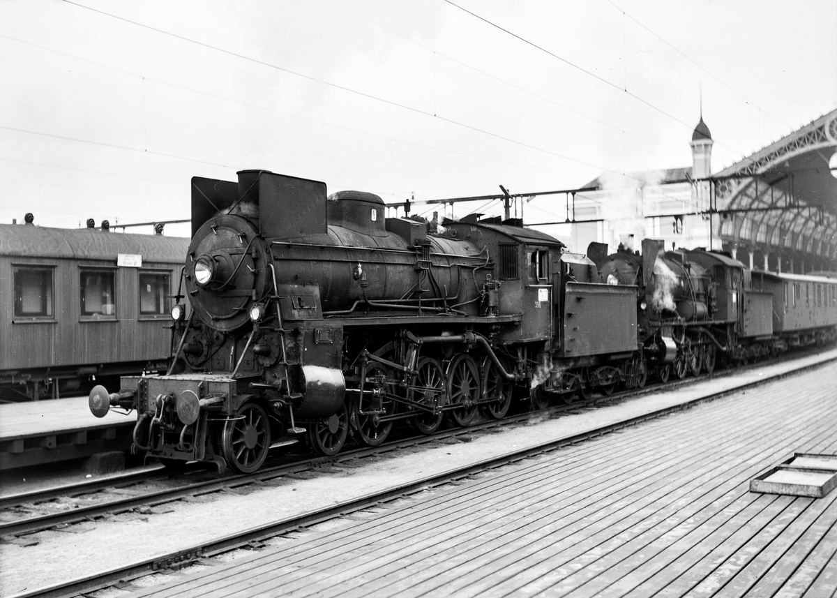 Damplokomotiv type 26c nr. 398 og damplokomotiv 30b nr. 347 på Oslo Østbanestasjon med tog til Gjøvik. Bak lokomotivet personvogn litra BDFo3-16 type 1 nr. 238 eller 239, opprinnelig levert til AS Valdresbanen.