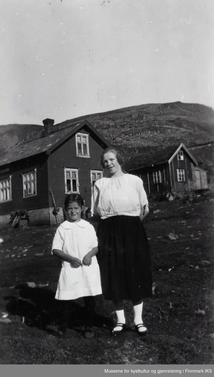 Nordvågen. Signe Klevstad og tjenestepike. Til venstre kommunalt "gjennomgangshus", til høyre Hans Ulriksens bolighus. Ca. 1930-35.