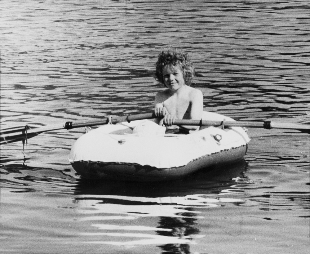 Helgeland Arbeiderblads sommerredaksjon på Herøy.(Påskrift konvolutt)
Gutt som ror gummibåt.