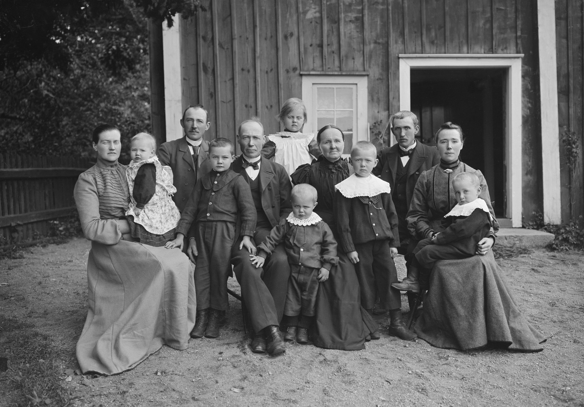 Familjen Markusson samlade framför hemmanet makarna äger i Flodlycke. Parets bägge barn har gift sig 1897 respektive 1898. Nu, några år i på det nya seklet, har de som synes begåvats med en skara barnbarn.