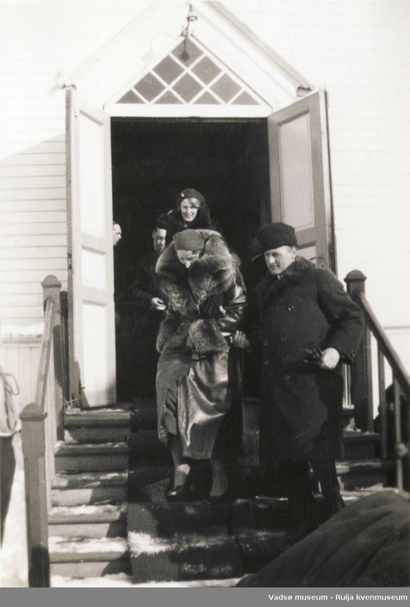Kronprins Olav og kronprinsesse Märtha på vei ut av Vadsø kirke under kronprinsparets besøk i Vadsø i 1934.Vi ser inngangspartiet til Grosch-kirken.