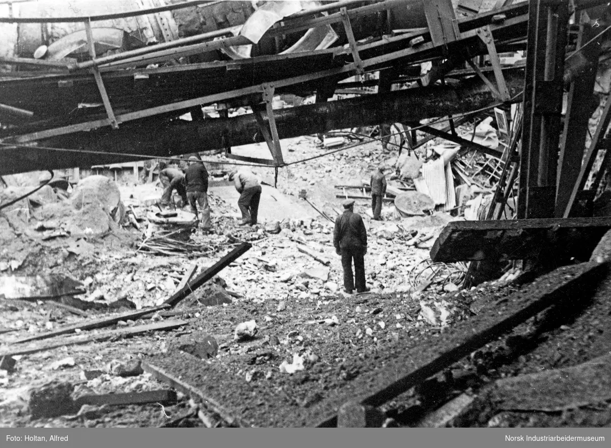 Mennesker leter i ruiner, i etterkant av alliert bombing av Vemork.
