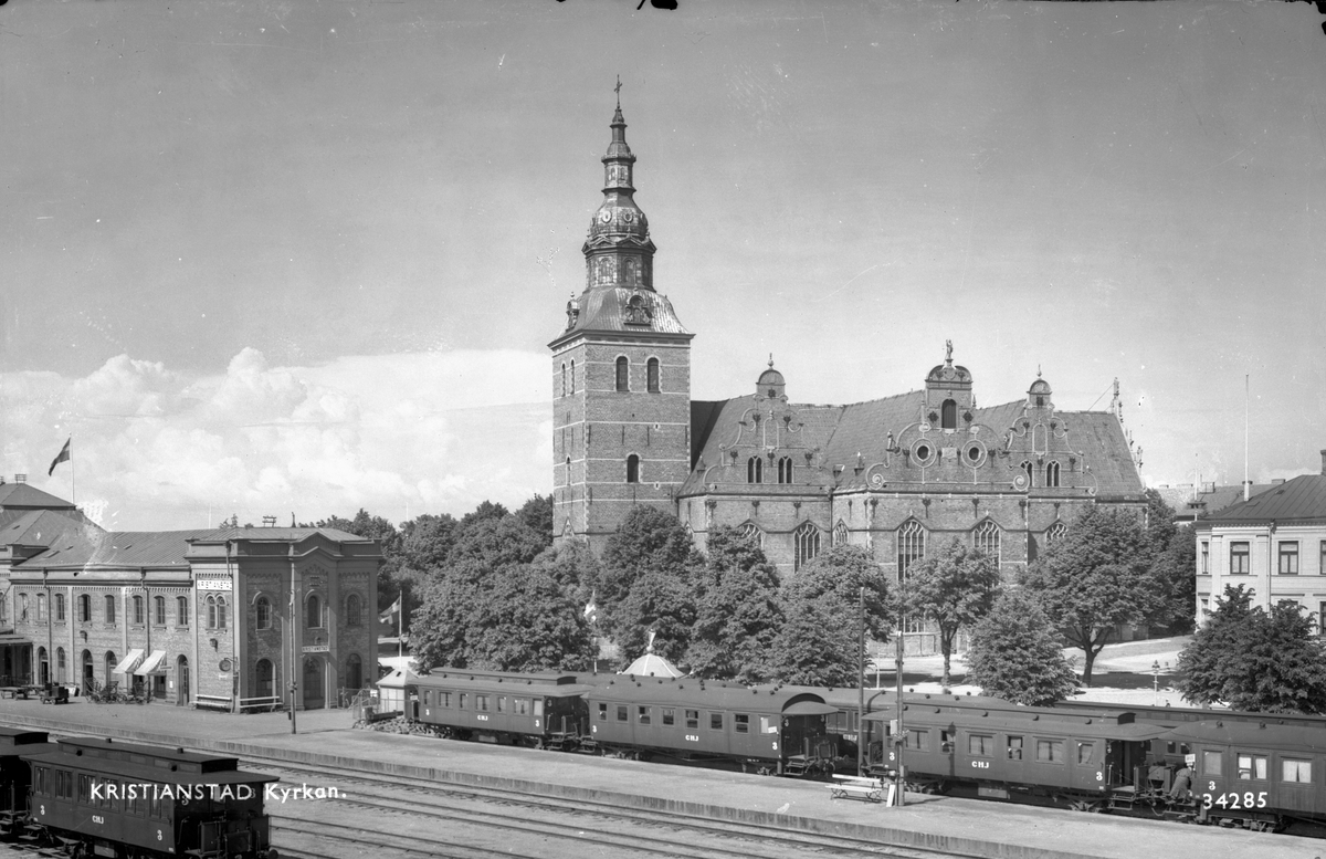 Kristianstad - Hässleholm Järnväg, CHJ-vagnar, vid Kristianstad Centralstation. I bakgrunden syns Heliga trefaldighetskyrkan.