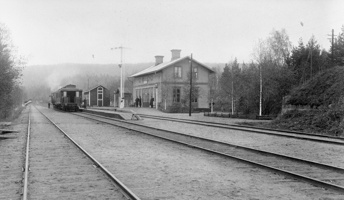Bergsgården stationshus med persontåg vid plattform.