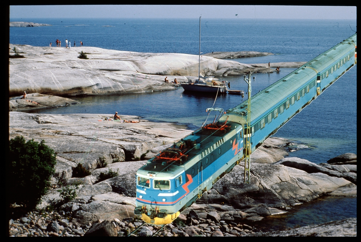 Bildmontage. Tågsätt med Statens Järnvägar, SJ Rc-lok bland badgäster.