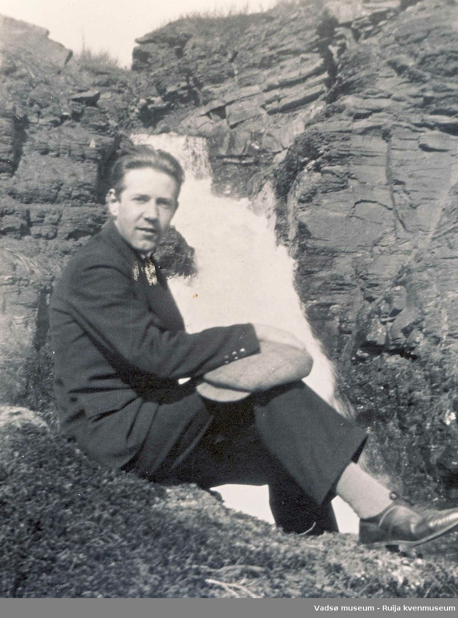 Gottfred Pedersen sitter ved en foss. Ca 1930.