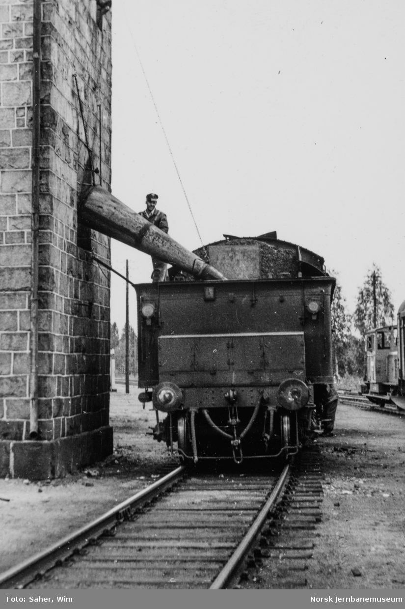 Damplokomotiv type 26a nr. 215 ved vanntårnet på Elverum stasjon. Bak til høyre skiftetraktor Skd 214 nr. 90.