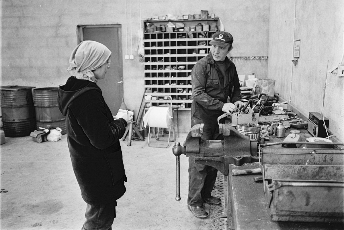 Antikvarie Kerstin Berg från Upplandsmuseet samtalar med traktorförare Folke Sundnäs i verkstaden, Hacksta gård, Enköpings-Näs socken, Uppland november 1981