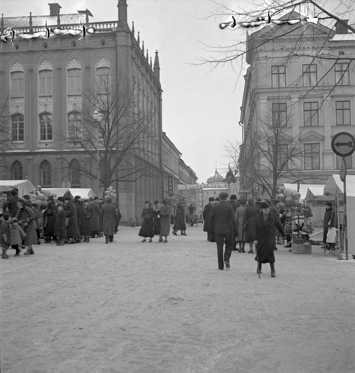 Hindersmässan i Örebro den 28 januari 1937. Vid Stortorget promenerar folk utmed Köpmangatan som korsar Stortorgets västra del. Till vänster syns Rådhuset och i fonden skymtar Slottet.