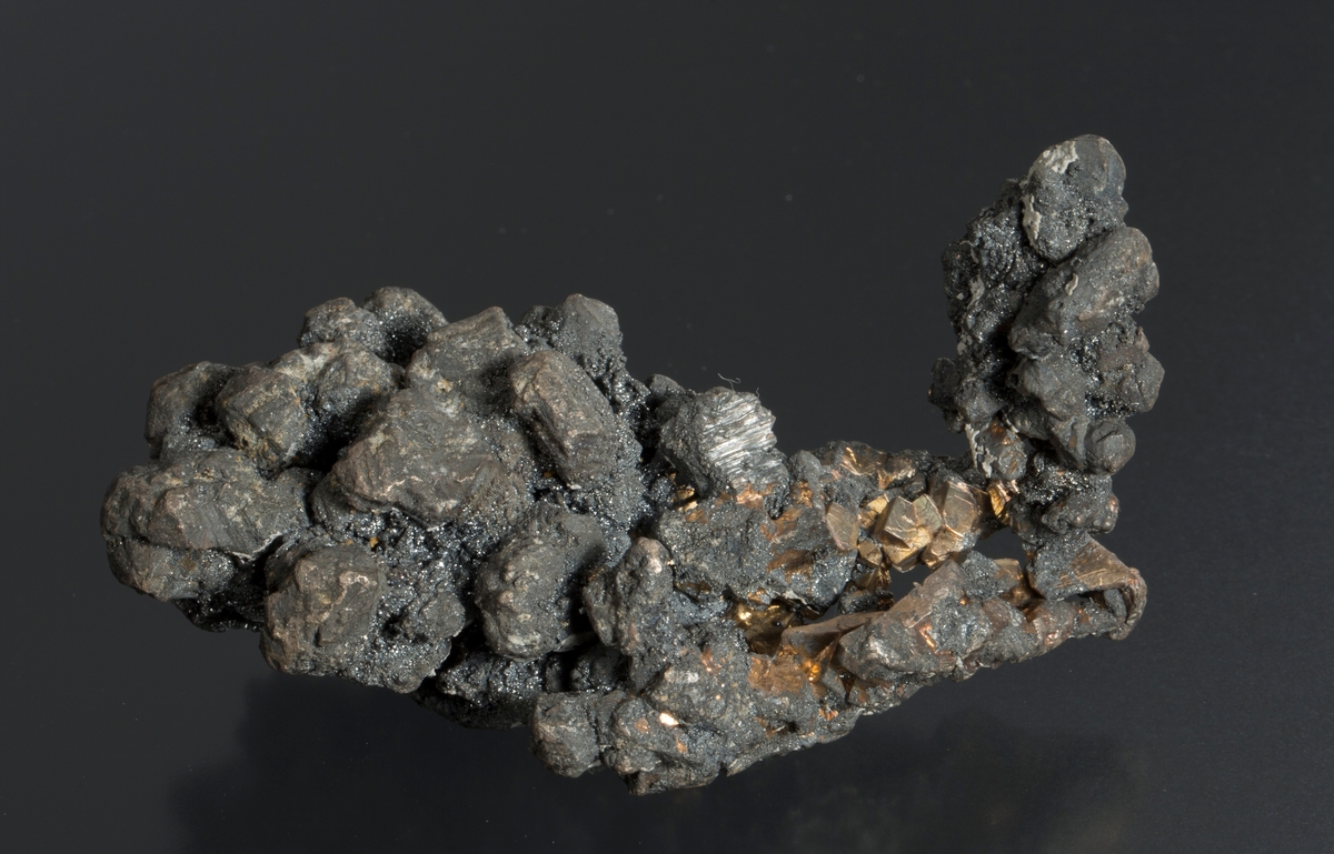 Krystaller, delvis dekket av acanthitt
Vekt 311,38 g
Størrelse: 8,5 x 5 x 4 cm

Lapp 52/6 "Rev nr" - 311 g

FSN: 52/6. Krystaller, de fleste dekket med acanthitt.