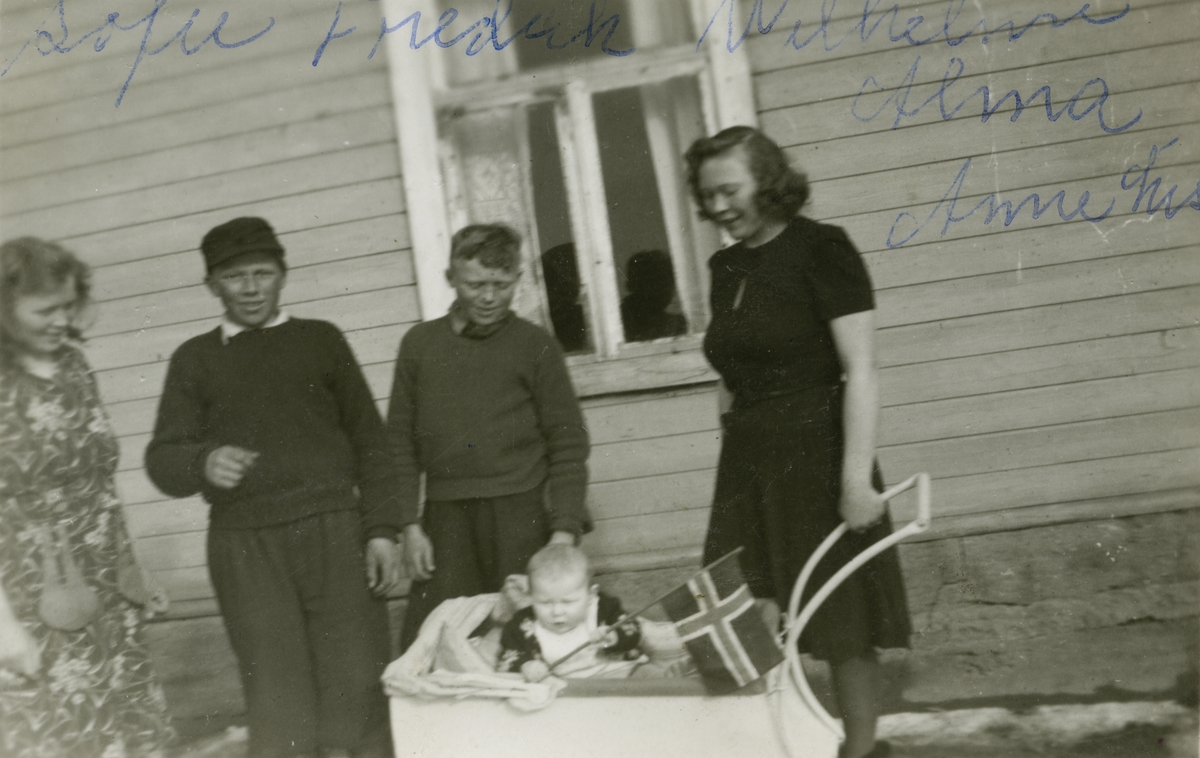 Familien Ittelin utenfor huset med barnevogn i Vestre Jakobselv.Fra venstre Sofie, Fredrik, Willhelm, Alma og Annelise (Ann Elisabeth) i vogna.