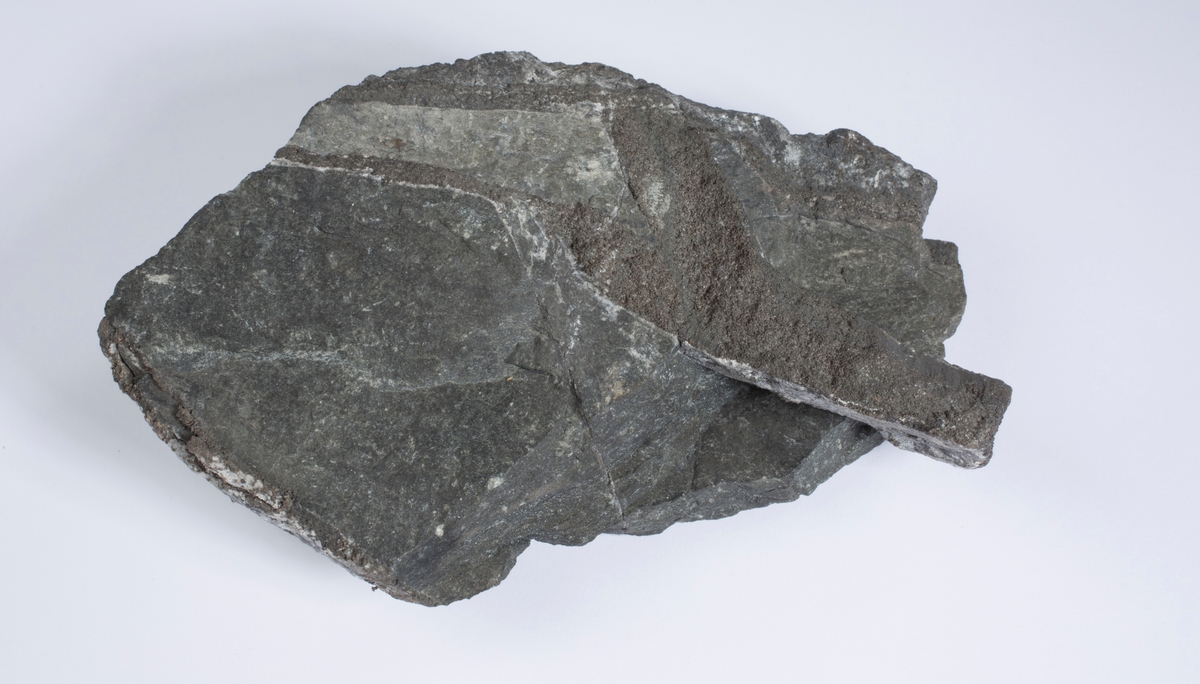 Sølvåre, 2,2 cm bred, i sidebergart
Vekt 1953,76 g
Størrelse: 16 x 15 x 6 cm

FSN: Breksjert åre 2.2 cm bred med bergart, sl.