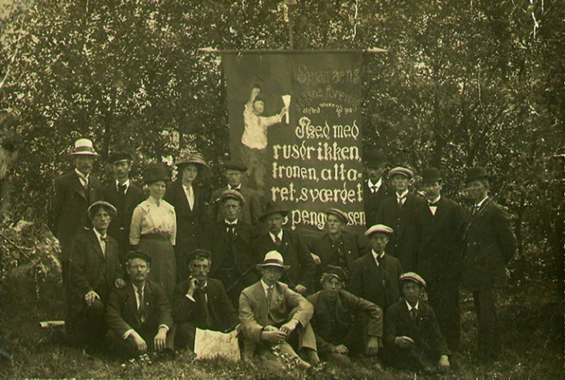 Spjærøy Ungsocialistiske forening med sin fane ved feiringen av lagets treårsdag 25. september 1913. Motto på fanen: «Ned med rusdrikken, tronen, alteret, sværdet og pengeposen». Foto: