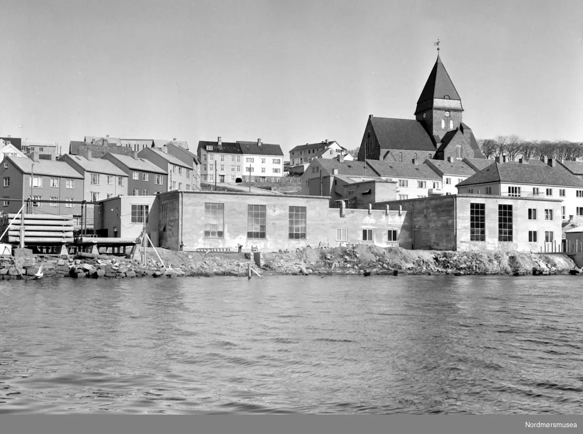Foto muligens fra rørarbeid på Nordlandet i Kristiansund. Det er Nordlandet kirke vi ser til venstre på bildet. Datering er trolig omkring 1950. Fotograf er Nils Williams. Fra Nordmøre museums fotosamlinger.